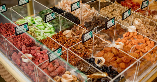 Bunte Auswahl gesunder Chips & Snacks, darunter Proteinriegel und Low-Carb-Kekse, auf einem Holztisch präsentiert – Ihr Guide zu how to choose chips & snacks.