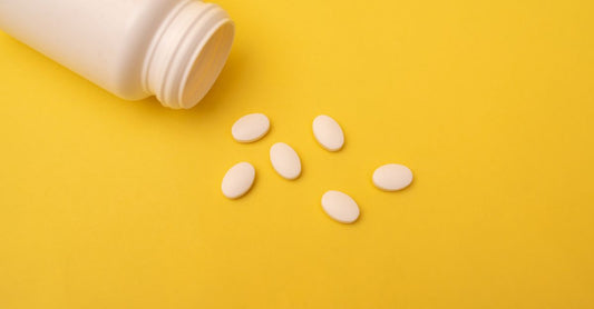 Best Calcium 2026 – Flache Anordnung von Calcium-Kapseln und -Tabletten auf hellem Hintergrund