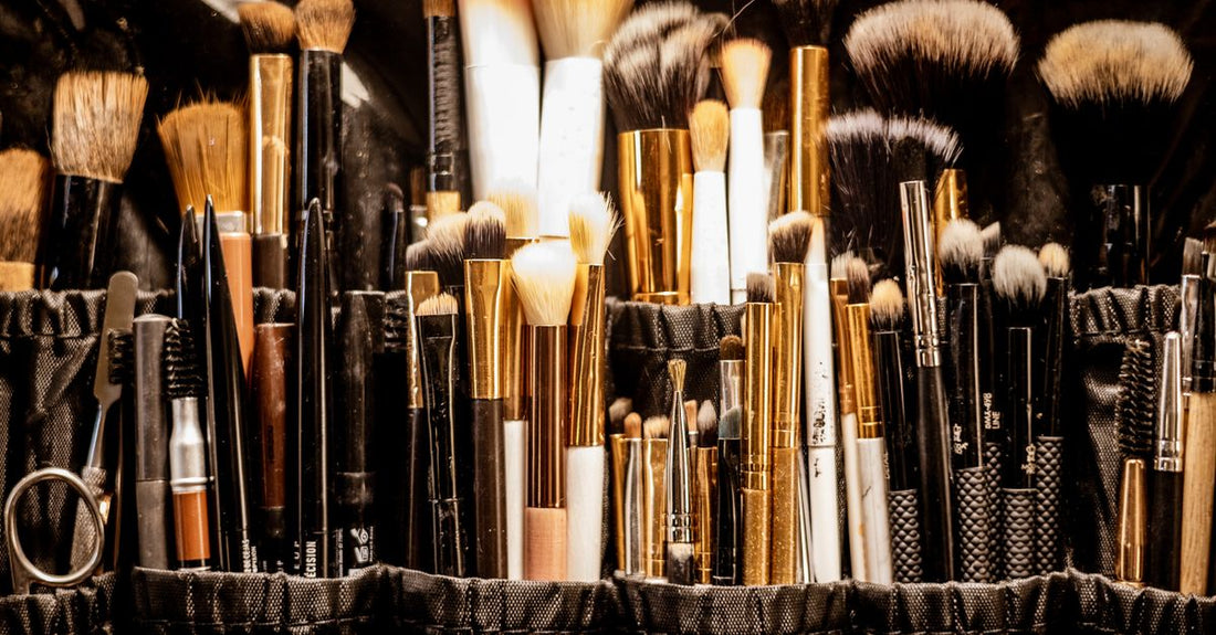 Beste Kosmetiktaschen 2026 – elegante Kosmetiktasche mit verschiedenen Make-up-Produkten auf Marmor