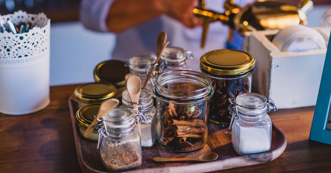 How to choose scrubs – ein Glas mit Zuckerpeeling und Holzlöffel auf hellem Hintergrund