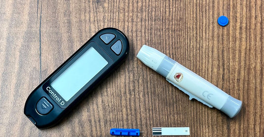 Ein Blutzuckermessgerät-Set mit Lanzetten, Teststreifen und Tragetasche auf einem weißen Hintergrund, ideal für das tägliche Diabetes-Management.