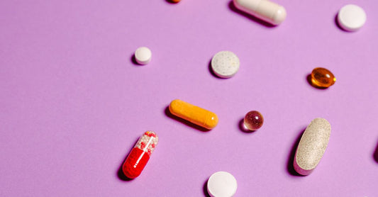 Verschiedene bunte Vitamin-Kapseln und Tabletten auf einer weißen Fläche – best multivitamine 2026