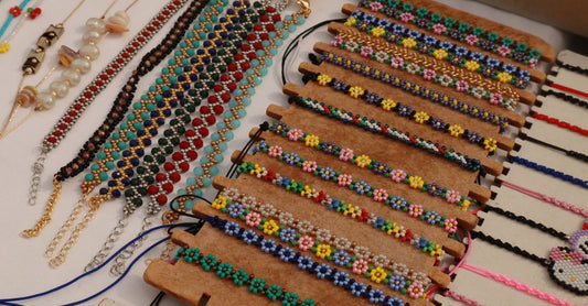 Armband-Kaufberatung: Mehrere Armbänder auf einem Holzuntergrund flach ausgelegt, verschiedene Materialien und Stile