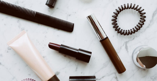Mascara Buying Guide: Eine schwarze Wimperntusche mit glänzender Verpackung liegt auf einer weißen Marmoroberfläche und symbolisiert hochwertige Beauty-Produkte.