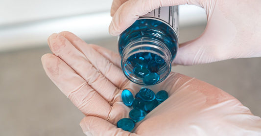 Flasche mit Charcoal Capsules gegen Blähungen und Gas auf einem weißen Tisch