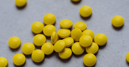 Eine Flasche Biotin (Vitamin B7) Nahrungsergänzungsmittel auf einem hellen Hintergrund, daneben liegen einzelne Kapseln – how to choose biotin (vitamin b7) Ratgeber