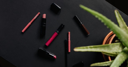 Eine flach liegende Anordnung von Lippenstiften in verschiedenen Farbtönen auf einem Marmorhintergrund für den Artikel Beste Lippenstifte 2026