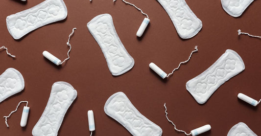 How to choose tampons: Eine flache Anordnung verschiedener Tampon-Schachteln mit Bio-Baumwoll-Tampons auf hellem Hintergrund.
