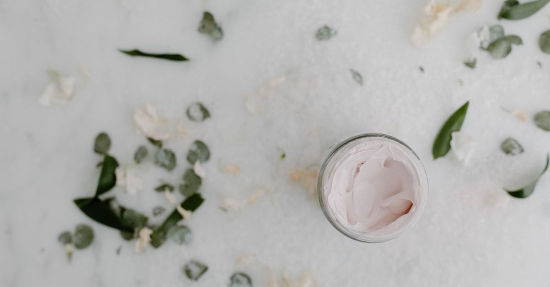 Best Moisturizers 2026: Verschiedene Feuchtigkeitscremes in Gläsern auf einem hellen Hintergrund arrangiert, mit grünen Blättern als Dekoration.