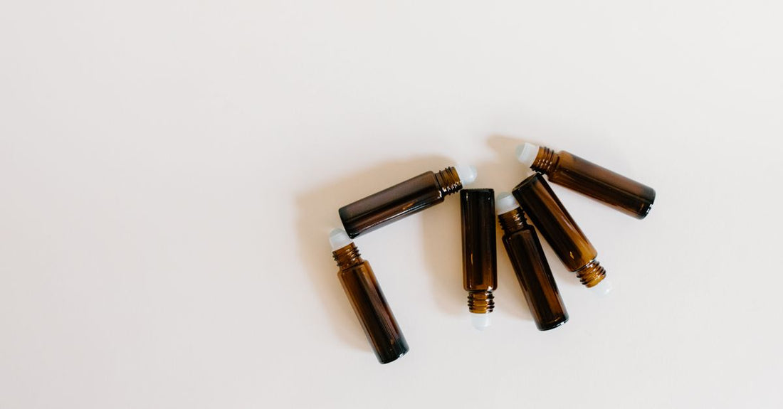 Mehrere hochwertige Glas-Roller-Bottles in verschiedenen Farben auf einer Holzoberfläche, ideal für die gezielte Anwendung ätherischer Öle.