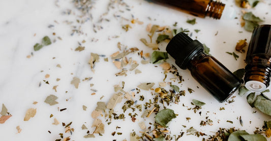Verschiedene Fläschchen mit ätherischen Einzelölen auf einem Holztisch, darunter Lavendel, Teebaum und Zitrone – best ätherische Einzelöle 2026