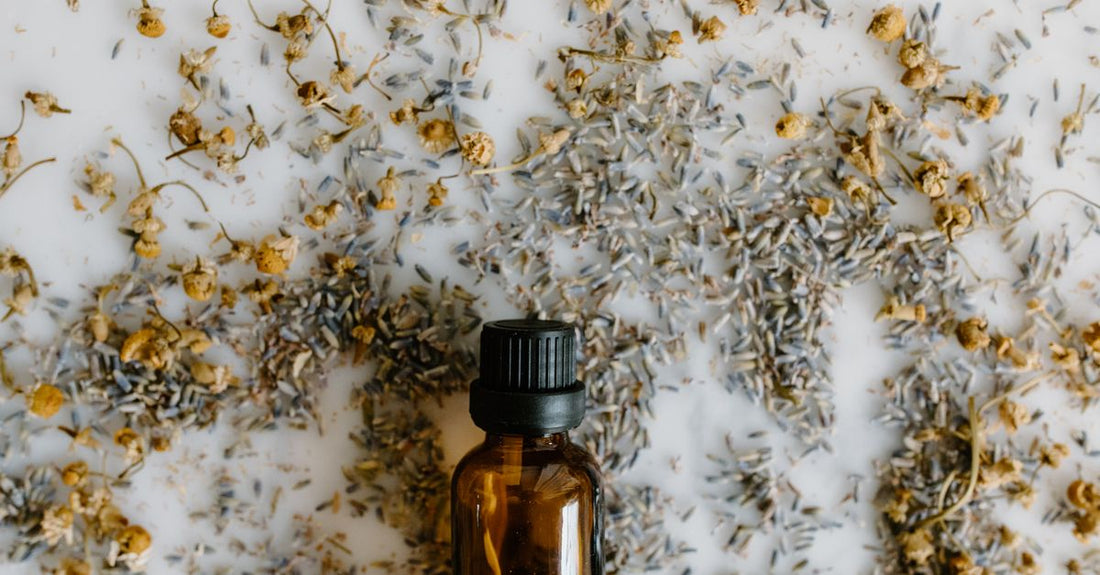 Lavendelöl-Flasche auf einem Holztisch mit getrockneten Lavendelblüten – natürliches Mittel für Schlaf und Angst