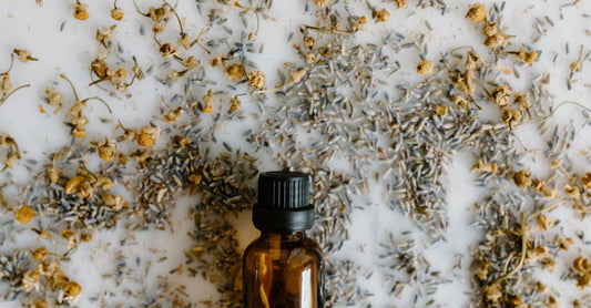 Lavendelöl-Flasche auf einem Holztisch mit getrockneten Lavendelblüten – natürliches Mittel für Schlaf und Angst
