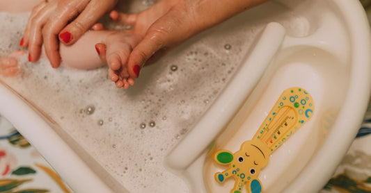 Baby Bubble Bath & Cleansers Buying Guide: Flasche mit mildem Babybad vor weichem Handtuch