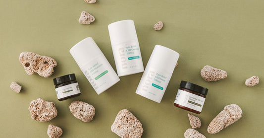 Natürliche Schmerzlinderungsprodukte wie Cremes und Gels auf einem Holztisch, beste alternative Schmerzlinderung 2026