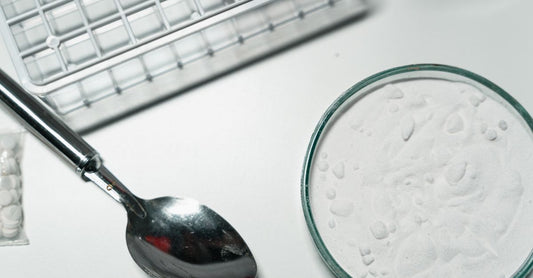 Weißes Pulver in einem Messlöffel auf dunklem Hintergrund, Beta Alanin für Ausdauer