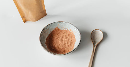Schüssel mit Maca-Wurzelpulver und Holzlöffel auf rustikalem Tisch, Maca root powder benefits for women
