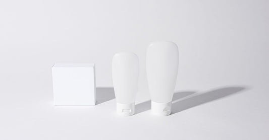 Scar cream for surgery scars best: Eine weiße Narbencreme-Tube auf einem minimalistischen Holztisch, daneben eine grüne Pflanze.