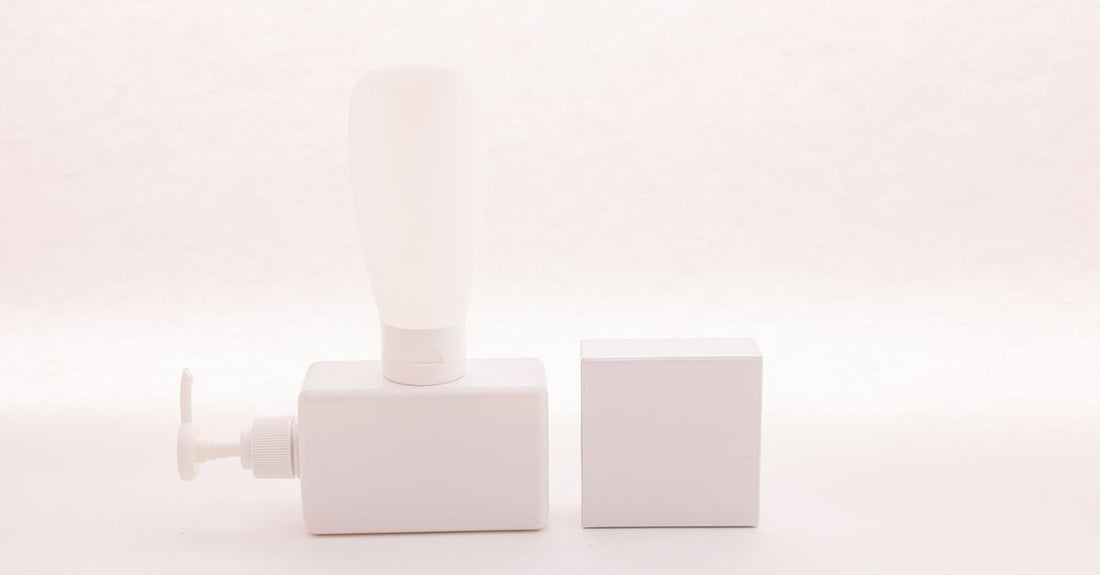 Beste Pumpenspender 2026: Nachfüllbare Glasflasche mit schwarzer Pumpe auf einer weißen Kommode im Badezimmer.