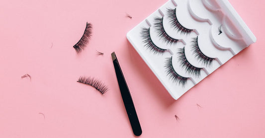 False Lashes Buying Guide: Verschiedene Stile falscher Wimpern auf weißem Hintergrund flach gelegt