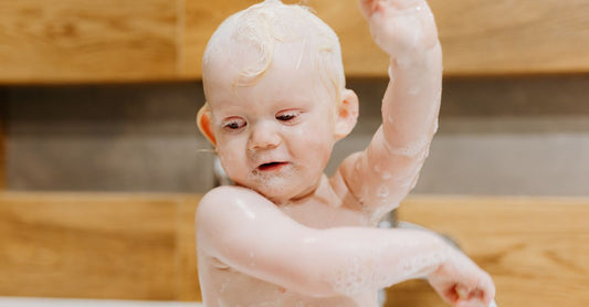 Flaschen mit Baby-Bubble-Bath und sanften Reinigern auf einem Badezimmerregal – Auswahlhilfe für Eltern.