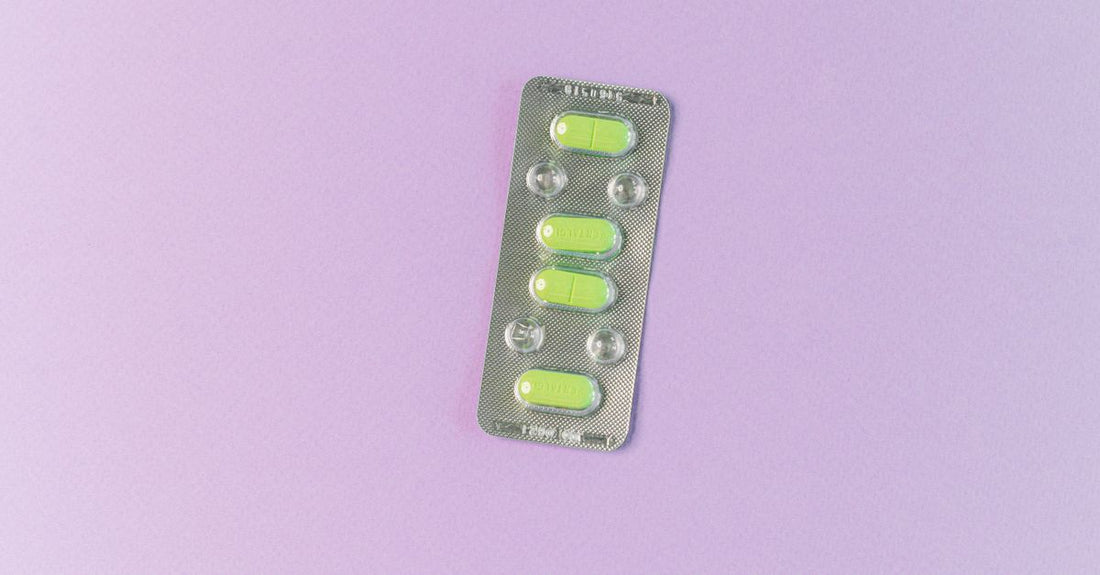 Packung mit UTI Pain Relief Tablets auf einem neutralen Hintergrund, daneben ein Glas Wasser, symbolisiert schnelle Hilfe bei Harnwegsinfekten.
