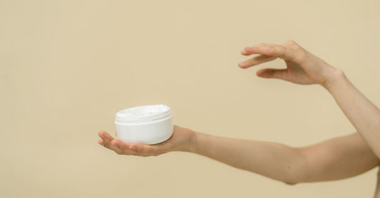 Dusting Powders Buying Guide – Weißes Körperpuder in einem Glasbehälter mit Puderquaste auf einem Badezimmerregal