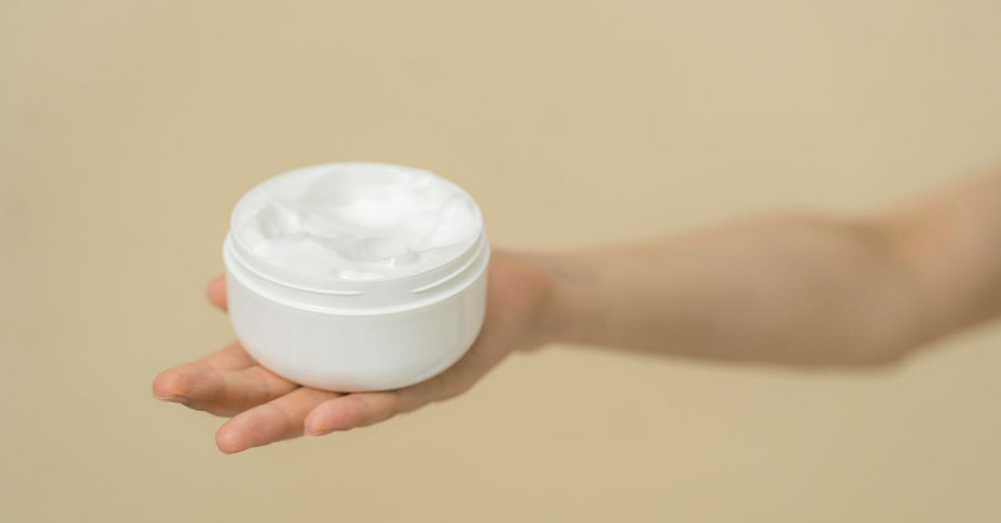 Eine weiße Dose mit Schmerzlinderungscreme für Arthritis, ideal für die tägliche Routine, auf hellem Hintergrund.