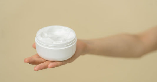 Eine weiße Dose mit Schmerzlinderungscreme für Arthritis, ideal für die tägliche Routine, auf hellem Hintergrund.