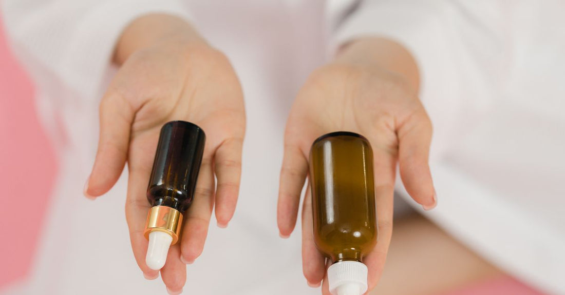 Verschiedene Flaschen mit Trägerölen auf einem Holztisch, bereit für die Anwendung in der Aromatherapie und Hautpflege – beste Trägeröle 2026